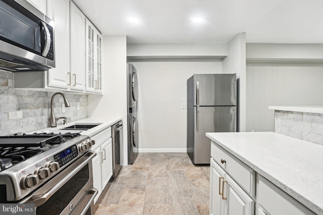 kitchen with white cabinets, backsplash, stainless steel appliances, and sink