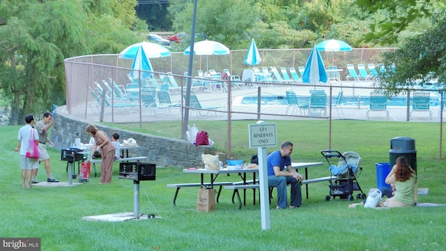 view of playground with a lawn and a community pool