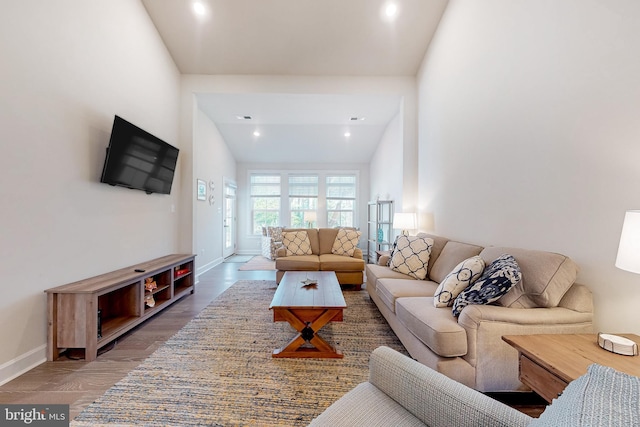 living room featuring high vaulted ceiling and hardwood / wood-style flooring