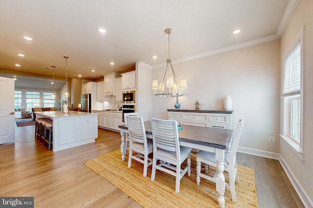 dining room featuring light wood-type flooring, sink, and ornamental molding