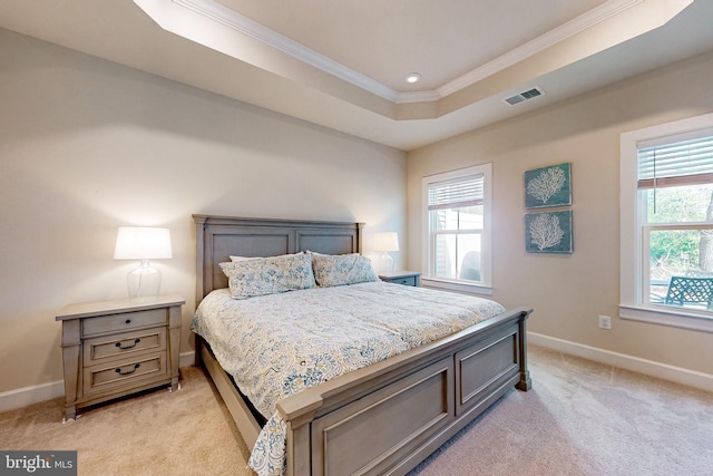 bedroom featuring light carpet, a tray ceiling, multiple windows, and crown molding