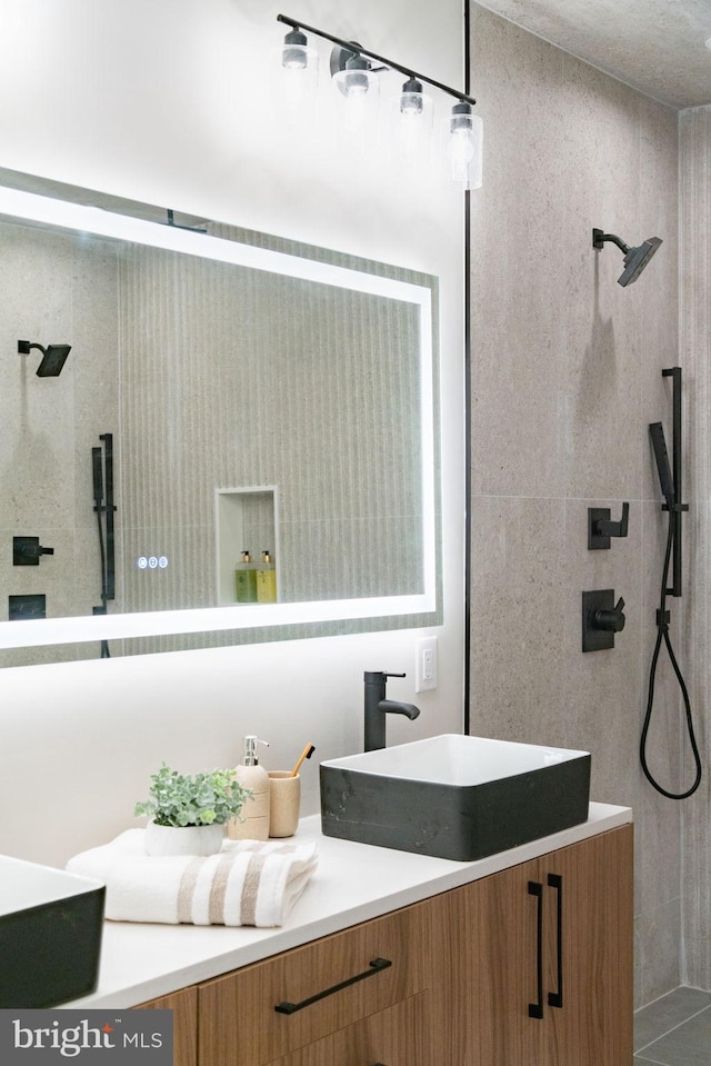 bathroom with vanity and a tile shower