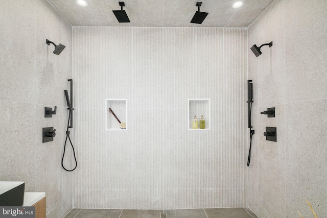 bathroom with tiled shower and tile patterned flooring