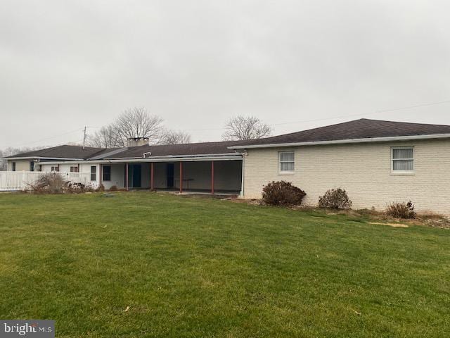 back of property with a lawn and a sunroom