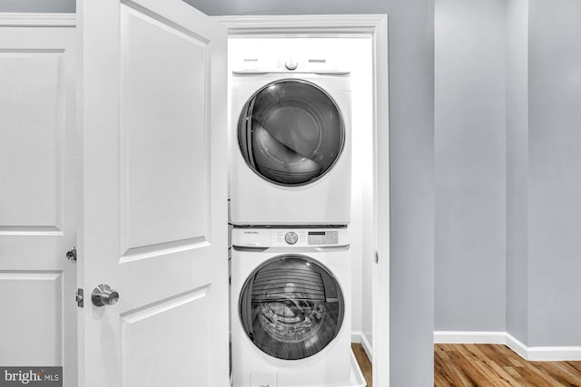 washroom featuring stacked washer and dryer and light hardwood / wood-style floors