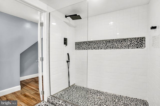 bathroom with hardwood / wood-style flooring and tiled shower