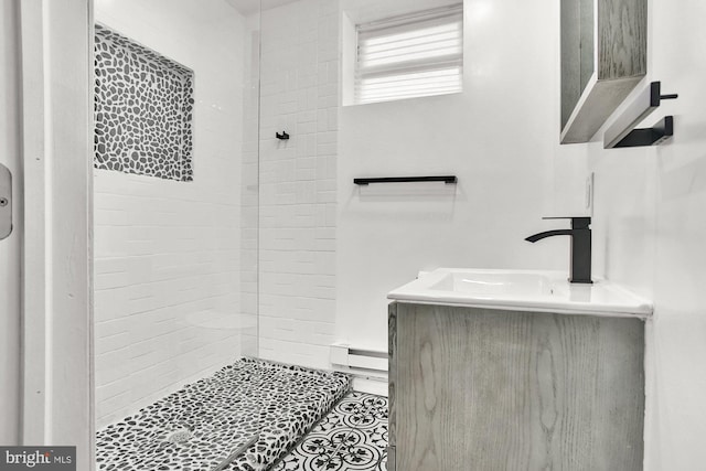 bathroom featuring vanity, a baseboard radiator, and tiled shower