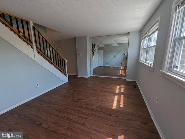 spare room featuring dark hardwood / wood-style flooring and a textured ceiling