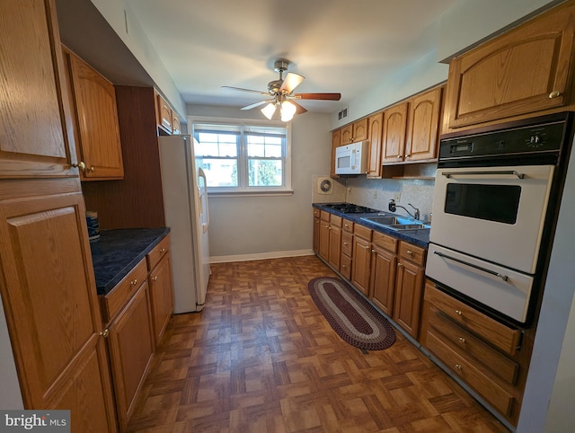 kitchen featuring white appliances, dark parquet floors, sink, decorative backsplash, and ceiling fan