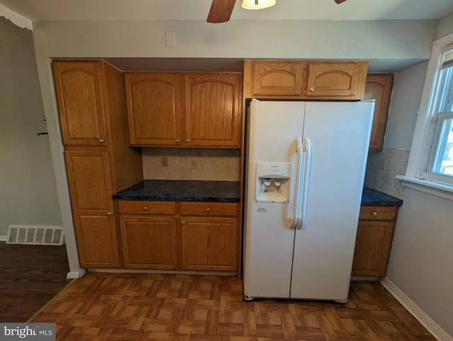 kitchen with decorative backsplash, white fridge with ice dispenser, ceiling fan, and dark parquet floors