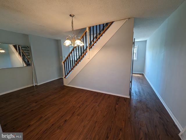 interior space featuring a notable chandelier, dark hardwood / wood-style floors, and a textured ceiling