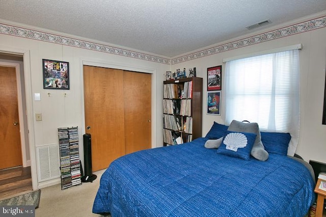 bedroom with light carpet, a textured ceiling, and a closet