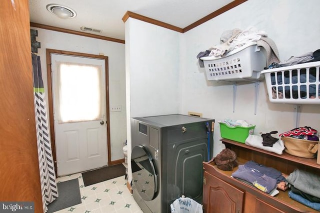 washroom with ornamental molding and washer / clothes dryer