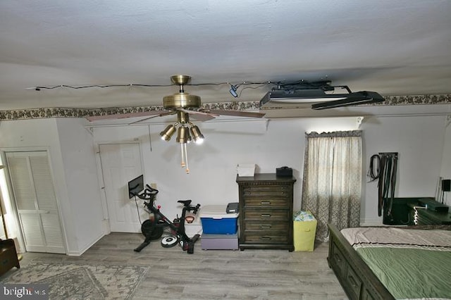 basement featuring light wood-type flooring and ceiling fan