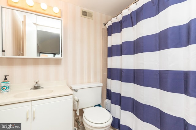 bathroom featuring a shower with shower curtain, vanity, and toilet