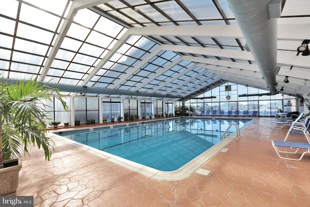 view of pool featuring glass enclosure and a patio