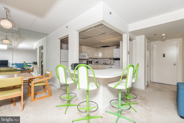 kitchen featuring a textured ceiling, white cabinetry, white appliances, and backsplash