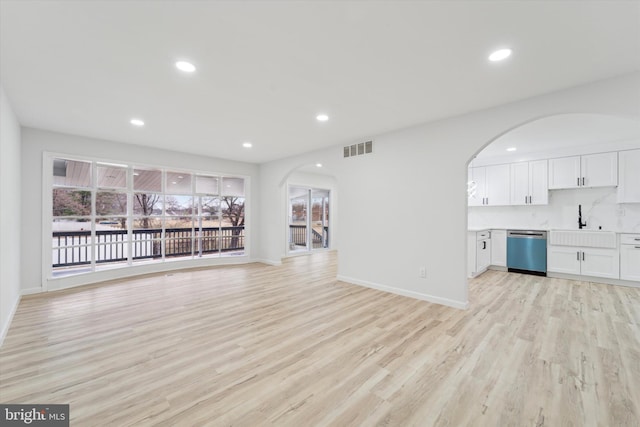 unfurnished living room featuring light hardwood / wood-style floors and sink