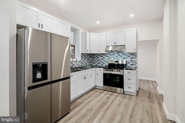 5907 Osage Ave, Philadelphia, PA 19143 - kitchen with stainless steel appliances, under cabinet range hood, tasteful backsplash, white cabinetry, and recessed lighting