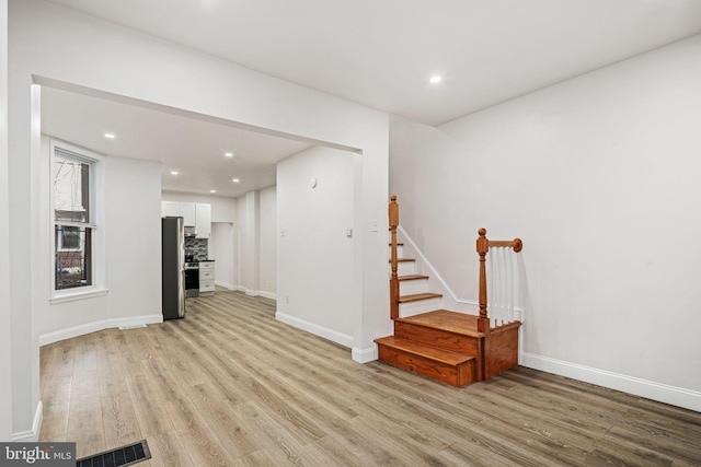 5907 Osage Ave, Philadelphia, PA 19143 - unfurnished living room with light wood-style flooring, stairs, baseboards, and recessed lighting