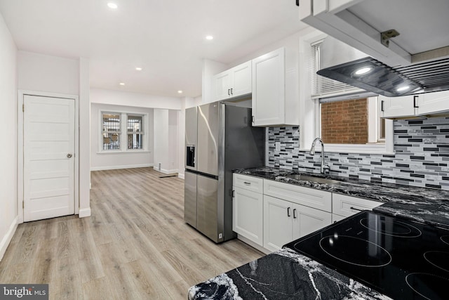 5907 Osage Ave, Philadelphia, PA 19143 - kitchen with stainless steel fridge, white cabinetry, a sink, decorative backsplash, and stove