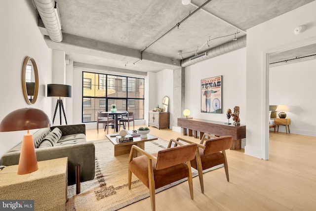 living room featuring rail lighting, baseboards, and light wood-type flooring