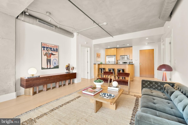 living area featuring light wood-type flooring and visible vents