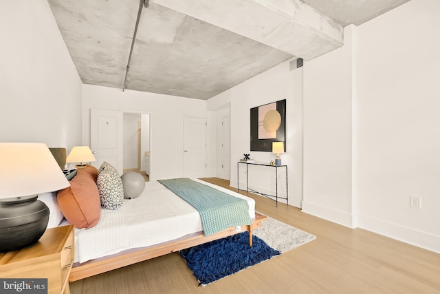 bedroom featuring visible vents, baseboards, and wood finished floors