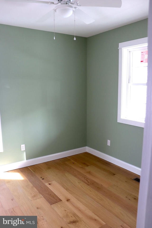 empty room with hardwood / wood-style flooring and ceiling fan