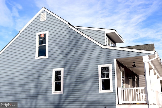 view of side of home featuring covered porch