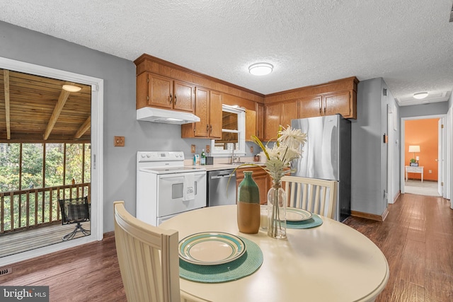 kitchen featuring dark hardwood / wood-style floors, beam ceiling, a textured ceiling, and appliances with stainless steel finishes