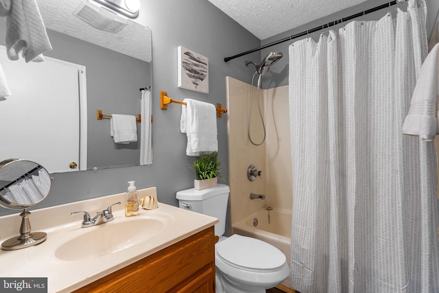 full bathroom with vanity, shower / bath combination with curtain, a textured ceiling, and toilet