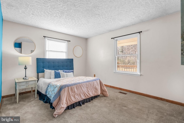 bedroom with a textured ceiling and carpet floors