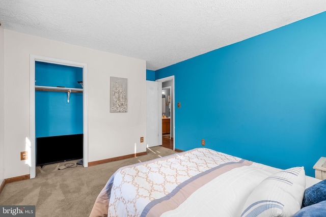 bedroom with a closet, light colored carpet, and a textured ceiling