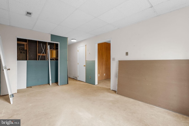 unfurnished room featuring carpet and a paneled ceiling