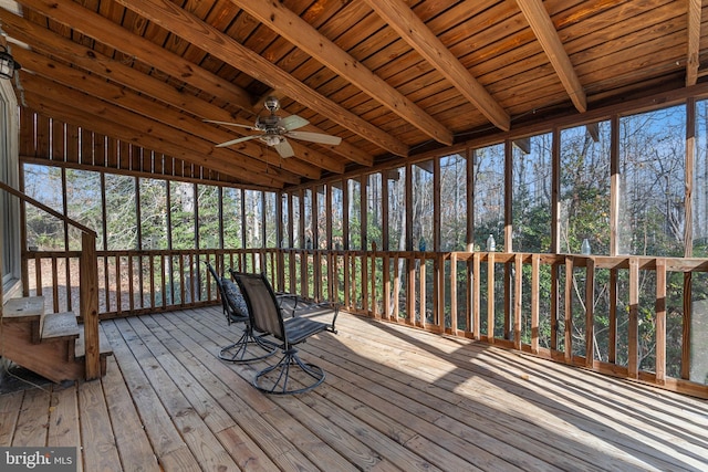 unfurnished sunroom featuring ceiling fan, lofted ceiling with beams, and wooden ceiling