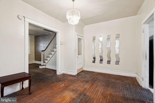 unfurnished room with dark hardwood / wood-style floors and a notable chandelier