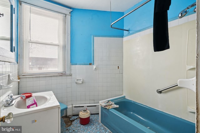 bathroom featuring tile walls, baseboard heating, tile patterned floors, vanity, and washtub / shower combination