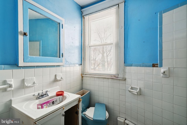 bathroom with tile walls, toilet, and vanity