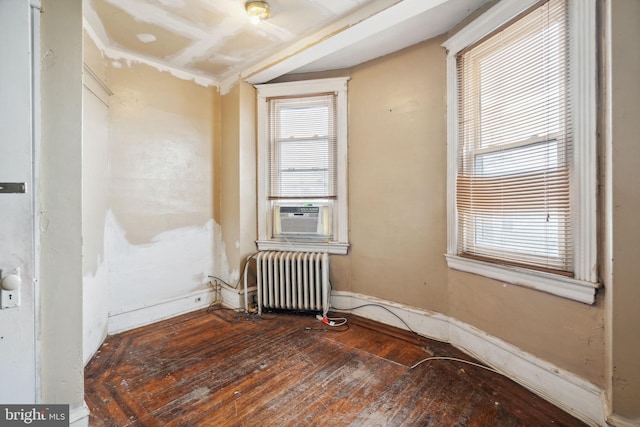 spare room with hardwood / wood-style floors, cooling unit, and radiator