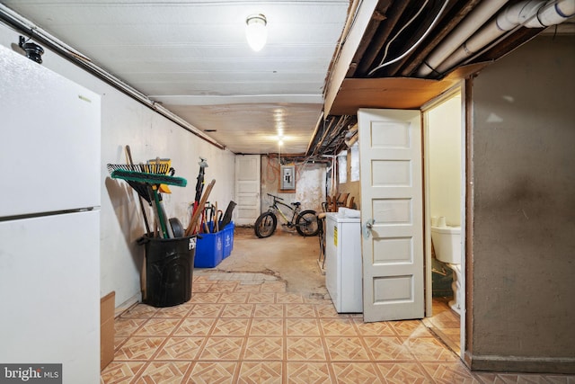 basement with electric panel, washer / dryer, and white fridge