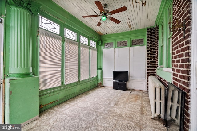 unfurnished sunroom with ceiling fan