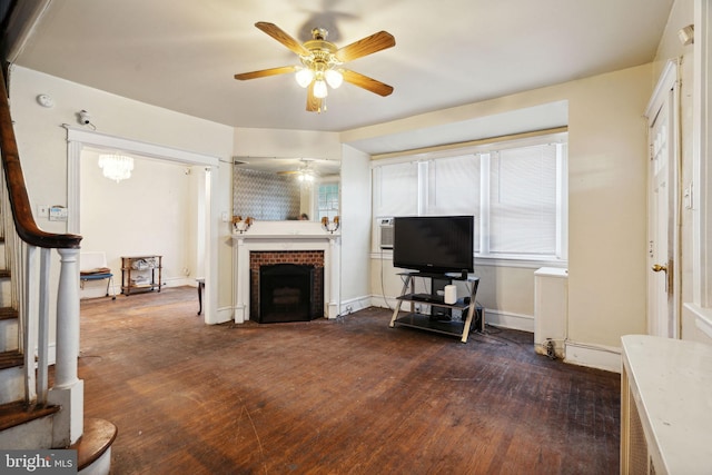 living room featuring ceiling fan, a brick fireplace, and dark hardwood / wood-style flooring