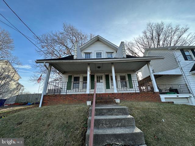 bungalow-style home with covered porch and a front lawn