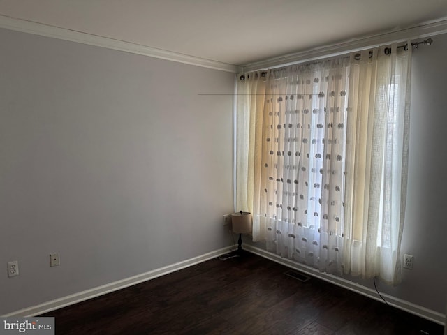 empty room featuring dark hardwood / wood-style flooring and ornamental molding