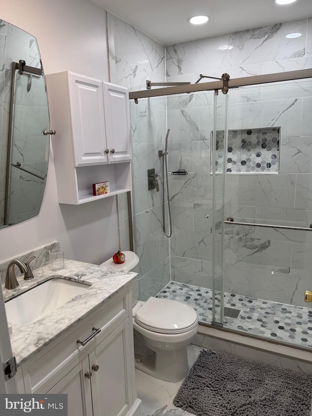 bathroom featuring vanity, toilet, and an enclosed shower