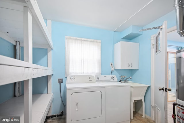 washroom with cabinets, washing machine and dryer, and light tile patterned flooring