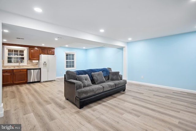 living room featuring light wood-type flooring and sink