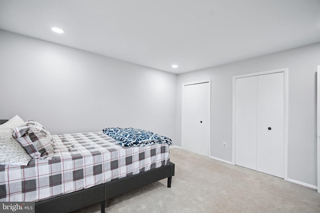 carpeted bedroom featuring multiple closets