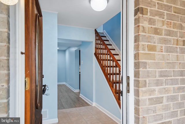 stairway with wood-type flooring and ornamental molding